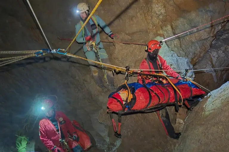 Herbstkurs der Höhlenrettung Eine Person auf einer Trage wird von mehreren Rettern in einer Höhle über eine Seilbahn abtransportiert