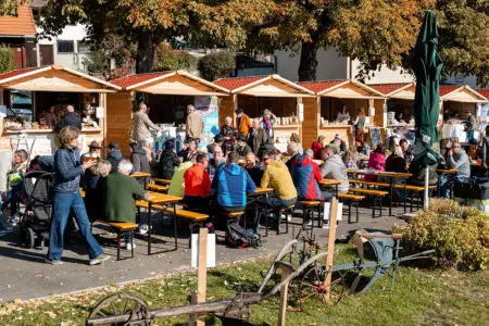 Kammern: Zwei Tage rund um den Genuss Zahlreiche Personen sitzen an Biertischen vor einer Reihe von Marktständen