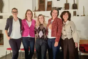 Fünf Frauen stehen vor einer Wand mit Ausstellungsstücken