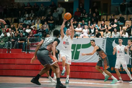Fünfter Sieg im fünften Spiel für die Kapfenberg Bulls Ein Basketballspieler der Kapfenberg Bulls setzt vor mehreren Gegenspielern zum Korbwurf an. Im Hintergrund verfolgen zahlreiche Zuschauer die Partie.