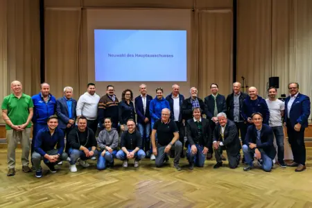 Eine große Gruppe von Personen posiert in einem Saal