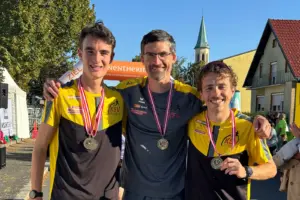 Drei erfolgreiche Leichtathleten des KSV Kapfenberg präsentieren nach einem Bewerb stolz ihre Medaillen. Bei strahlendem Sonnenschein posiert das Trio gemeinsam für ein Erinnerungsfoto.