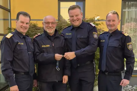 Krieglach: Führungswechsel bei der Polizei Vier Männer in Polizeiuniformen stehen vor einem gelben Haus