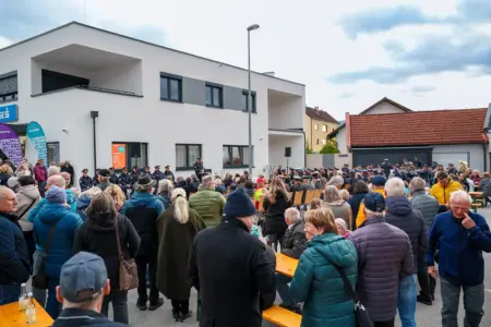 Zahlreiche Personen stehen vor einem Gebäude