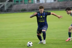 Ein Fußballer läuft hinter einem Ball.