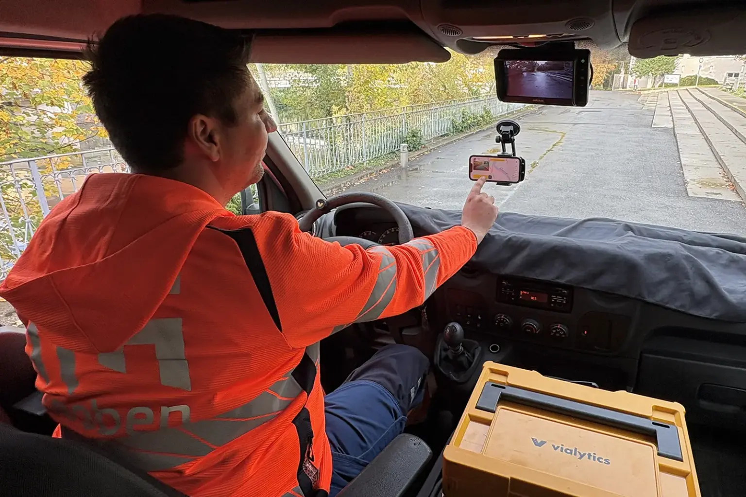 Ein Mann am Steuer eines Autos bedient ein Smartphone