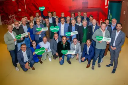Eine Gruppe von rund 35 Personen, manche von ihnen halten herzförmige Schilder in Händen