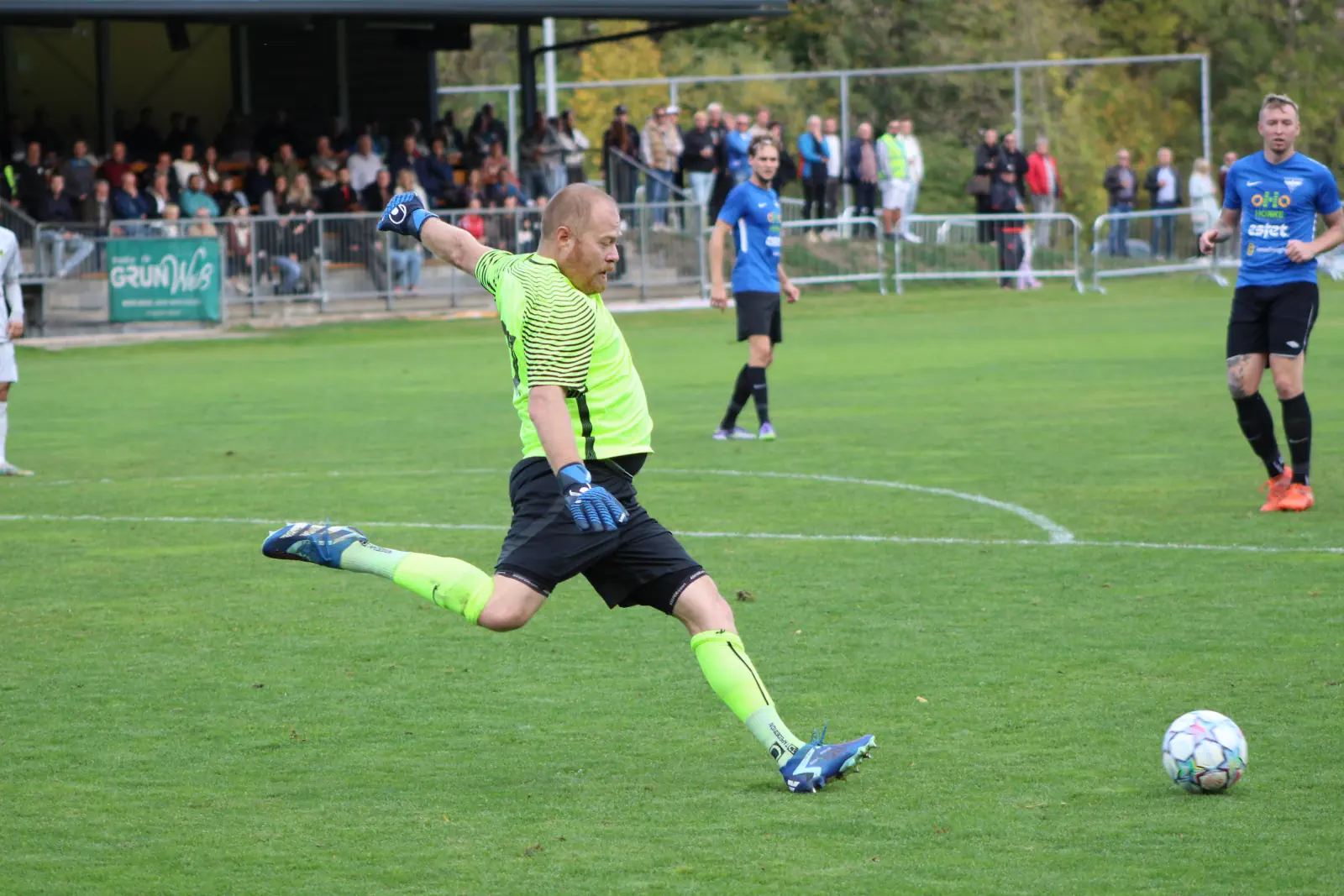 Ein Fußballtorhüter schießt den Ball weg.
