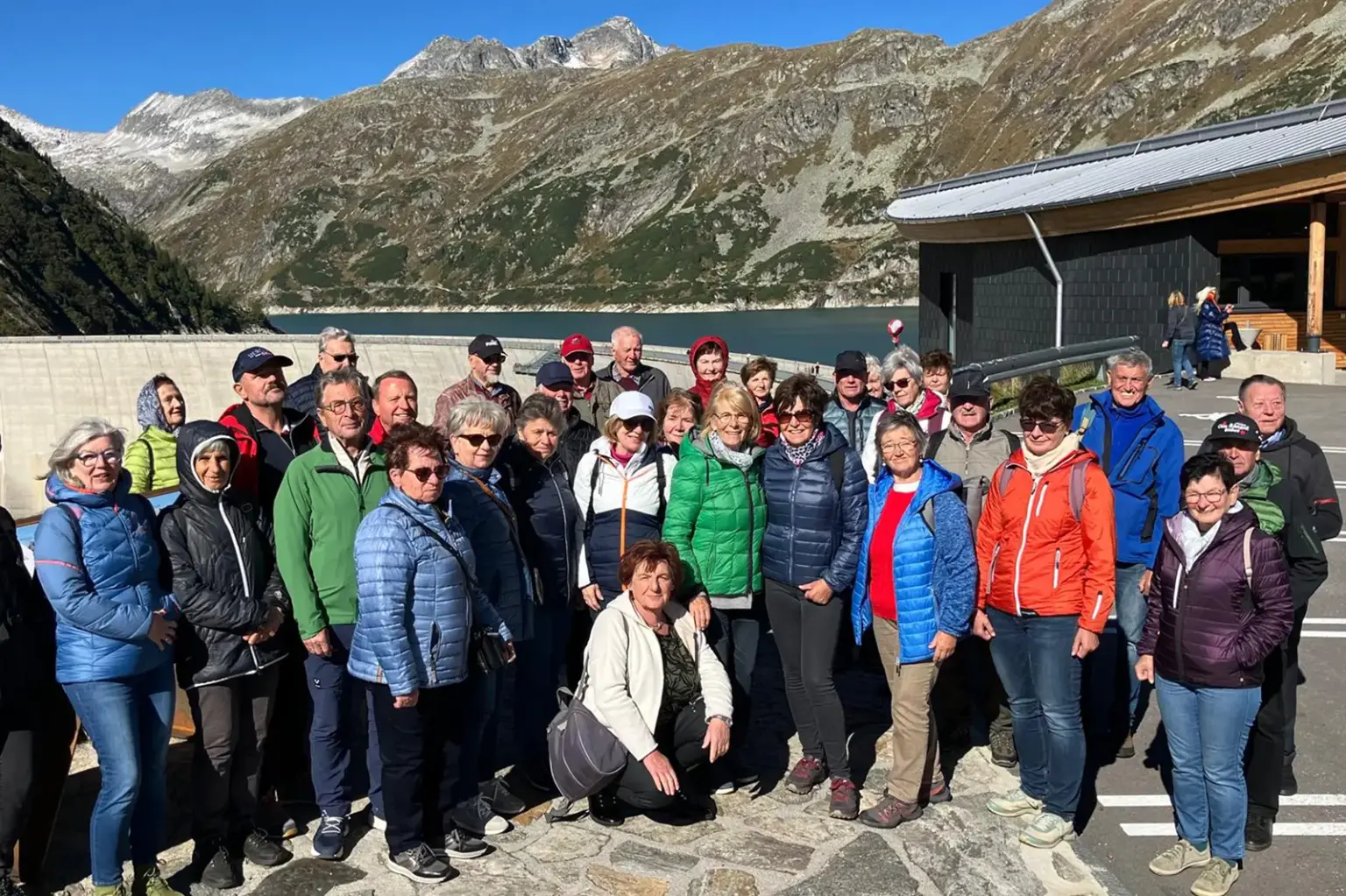 Seniorenbund Kapellen unterwegs in Kärnten Eine Gruppe von älteren Menschen steht auf einer Aussichtsplattform vor einem Staudamm