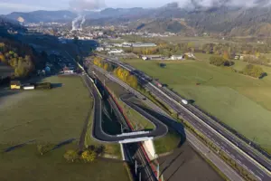 Eine Brücke über eine Bahnstrecke mit einer Ortschaft im Hintergrund