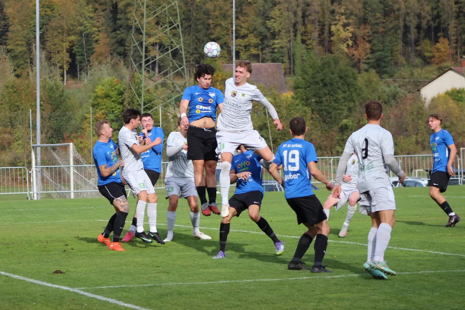 Zwei Fußballmannschaften beim Kopfballduell.
