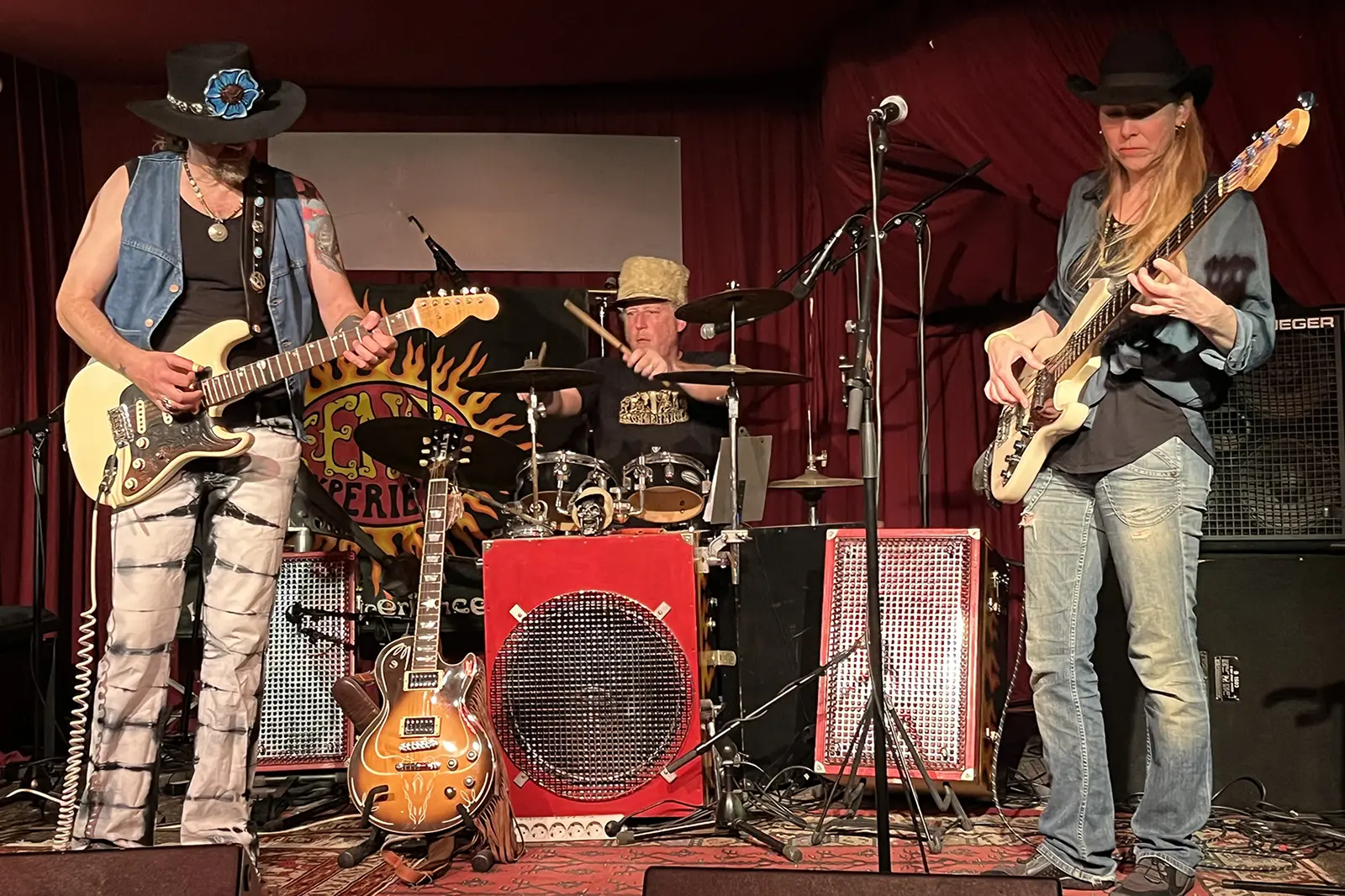 Drei Musiker mit Cowboyhüten spielen auf einer Bühne