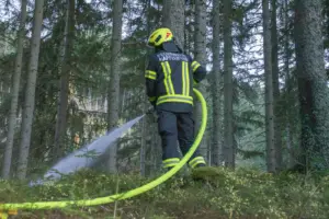 Ein Feuerwehrmann bei Löscharbeiten im Wald