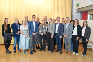 Eine größere Gruppe von Personen steht in einem großen Saal