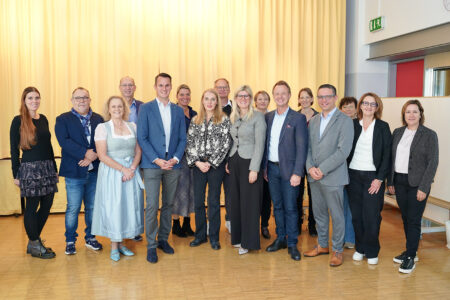 Erste Partnerklasse des Bezirks Leoben in Trofaiach Eine größere Gruppe von Personen steht in einem großen Saal