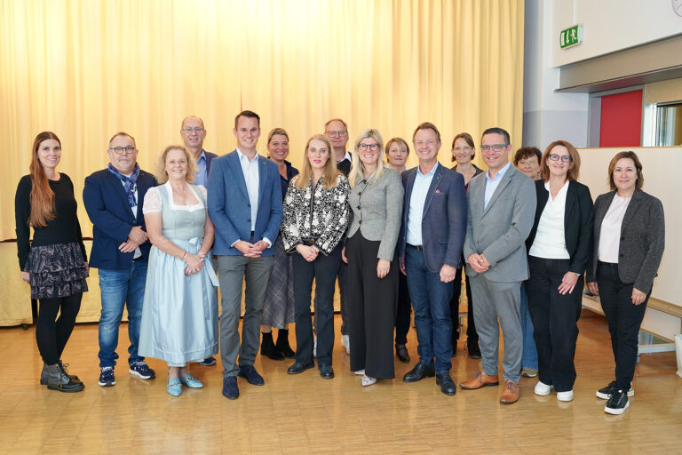 Eine größere Gruppe von Personen steht in einem großen Saal