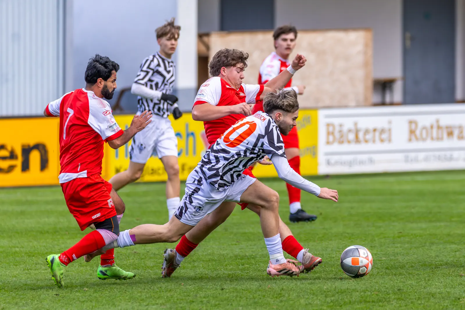Fünf Fußballer kämpfen um den Ball.