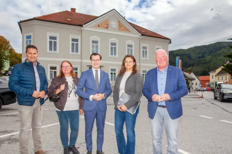 Umfangreiche rote Bilanz in Turnau Zwei Frauen und drei Männer stehen lächelnd auf einem innerörtlichen Platz vor einer sanierten Gebäudefassade