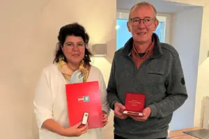 Ein Mann und eine Frau halten eine Urkunde und eine Schatulle