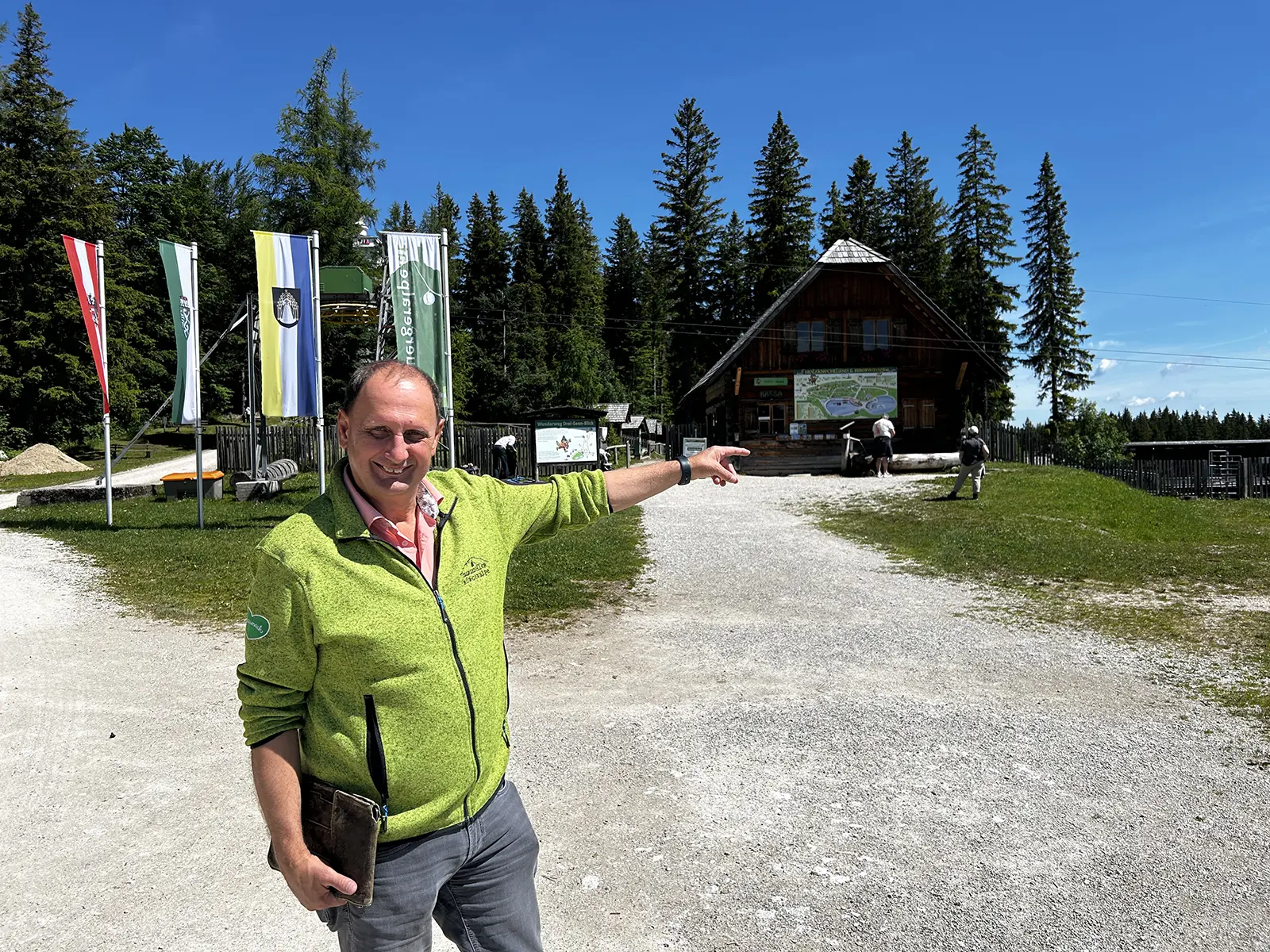 Ein Mann mit grüner Jacke zeigt auf eine Attraktion in Mariazell.