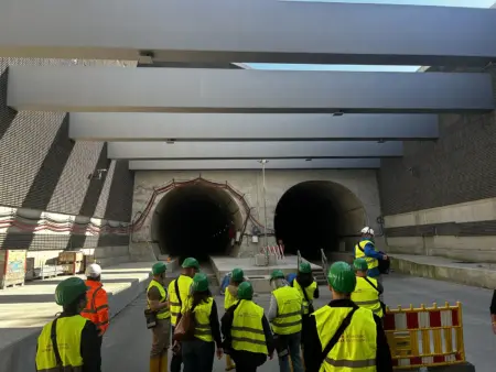 Eine Gruppe Menschen vor einem Tunnelportal.